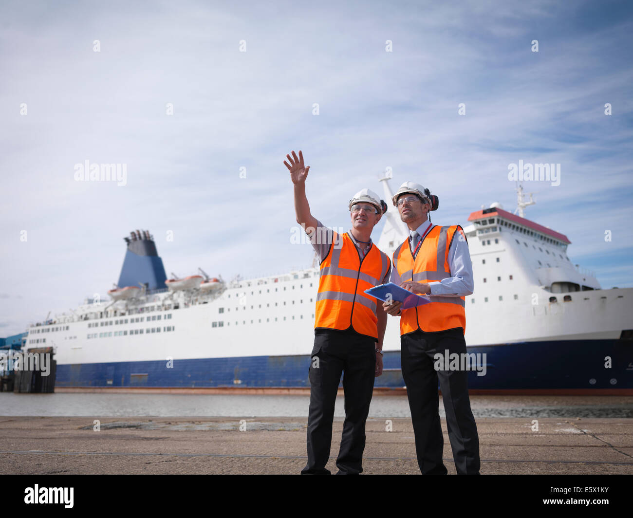 Port workers with ship in port Stock Photo