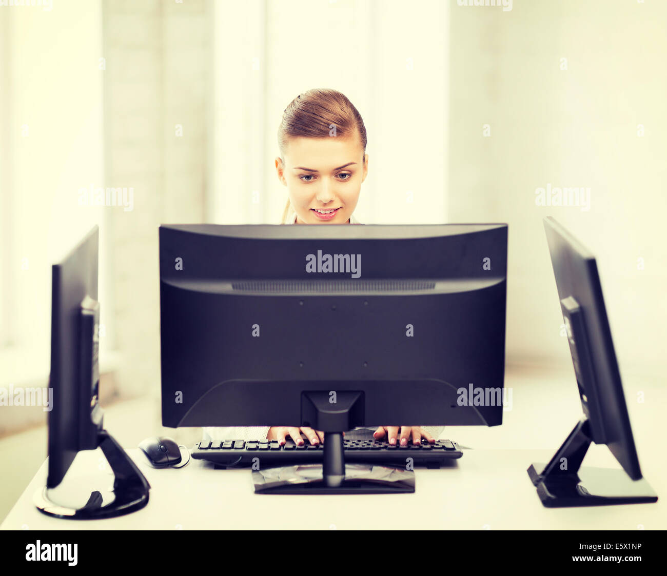 businesswoman with computer and monitors in office Stock Photo