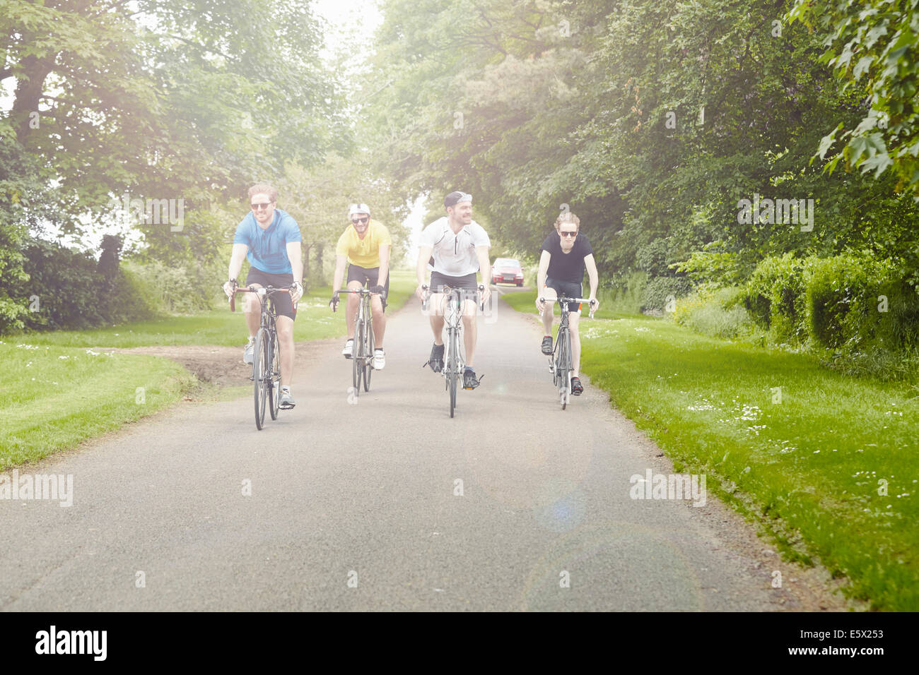 Cyclists riding on leafy countryside road, Cotswolds, UK Stock Photo