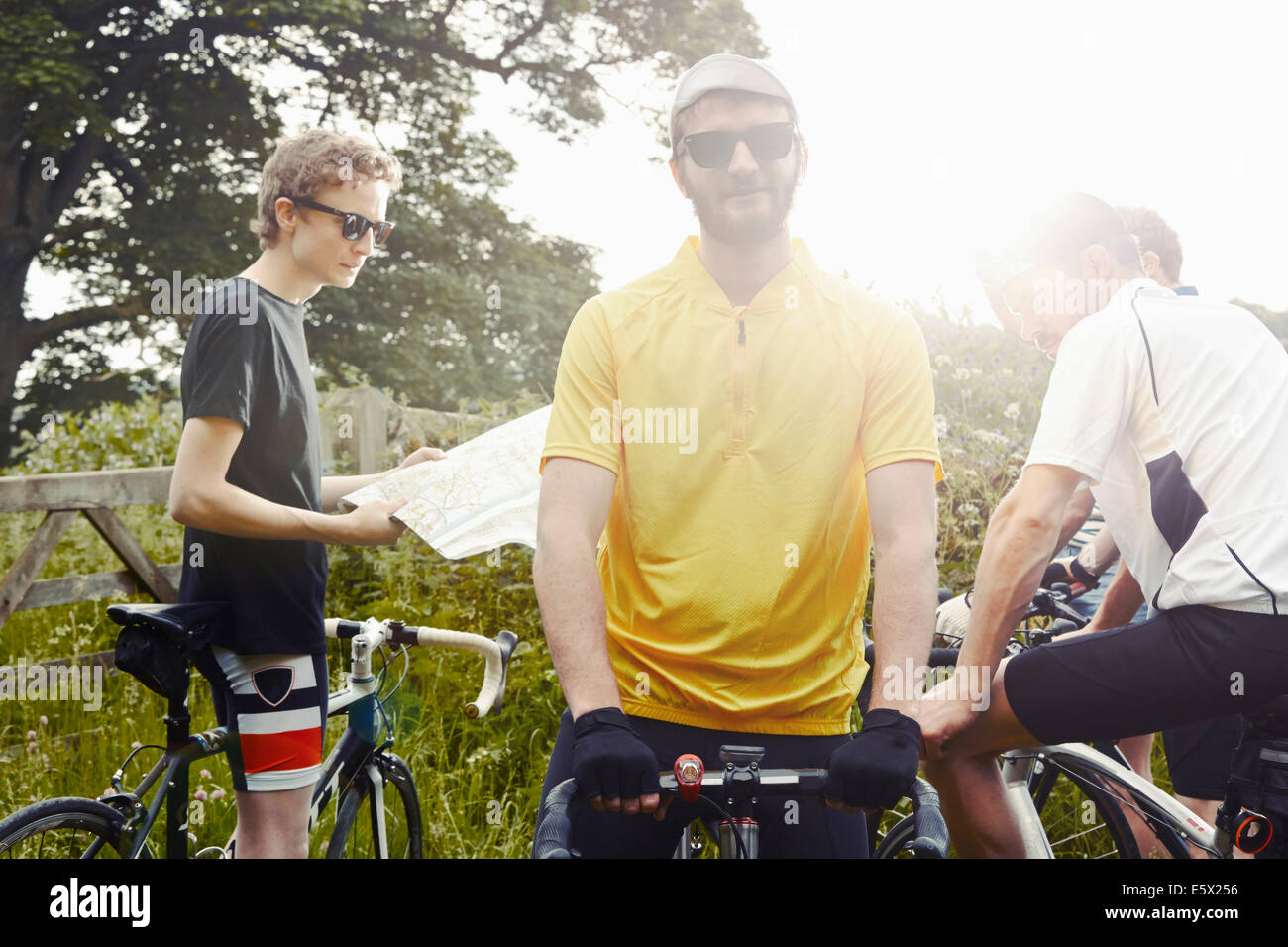Cyclists stopping on leafy countryside lane, Cotswolds, UK Stock Photo