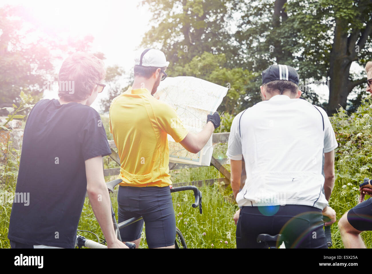 Cyclists map reading on countryside lane, Cotswolds, UK Stock Photo
