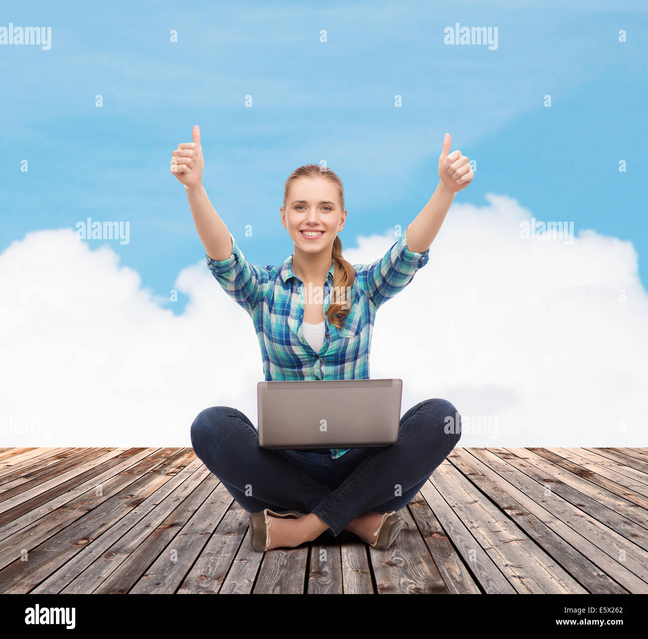 smiling woman with laptop and showing thumbs up Stock Photo - Alamy