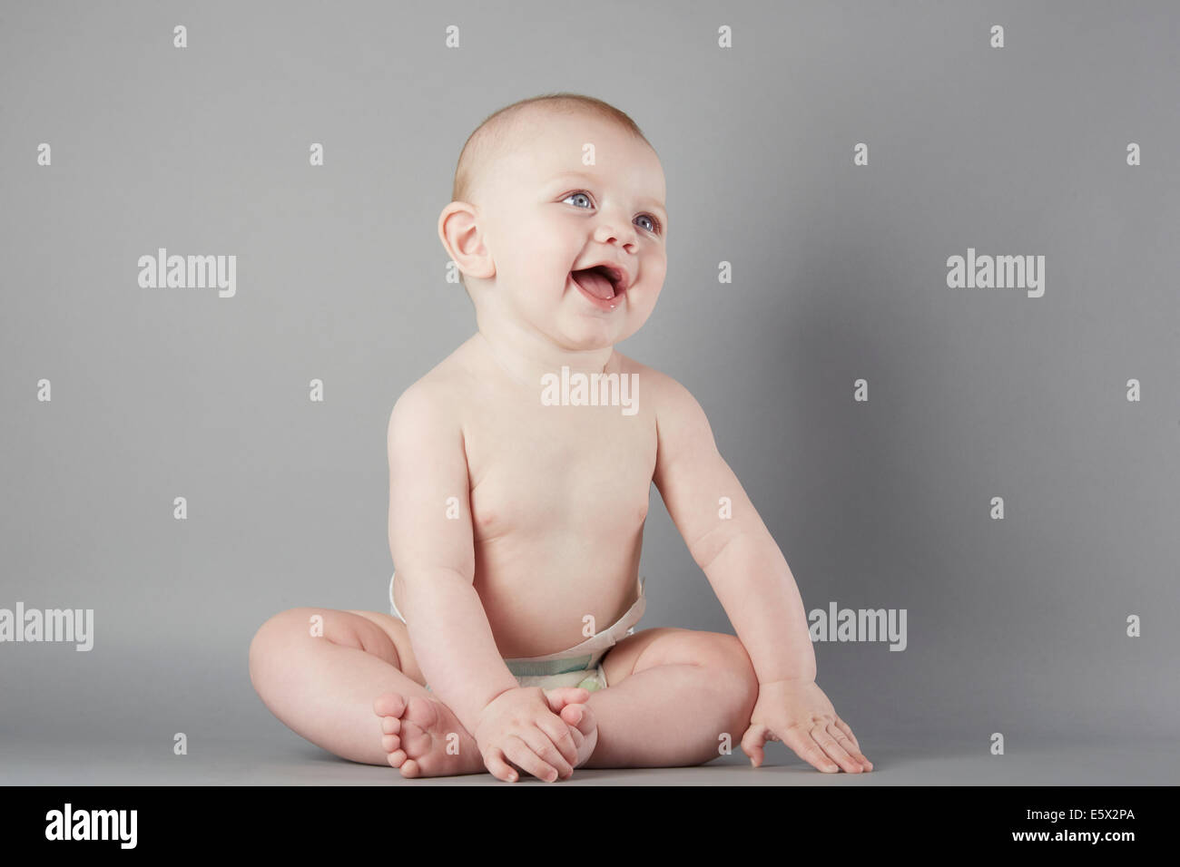 Studio portrait of curious baby boy sitting up Stock Photo