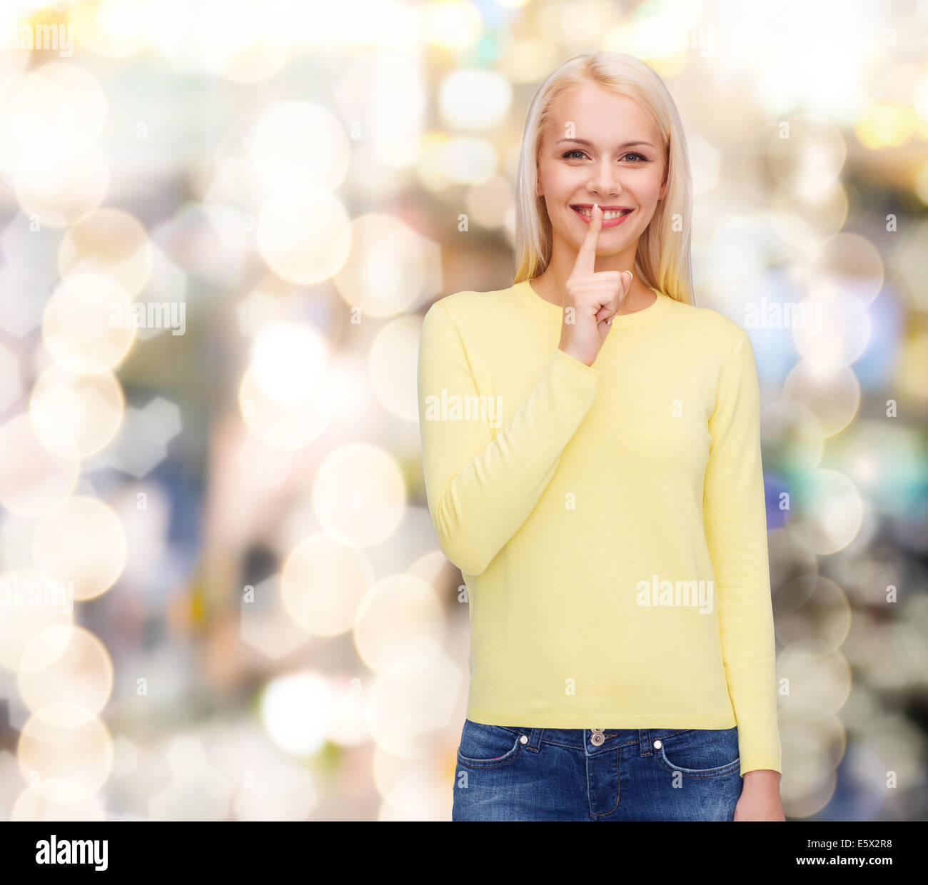 young woman with finger on her lip Stock Photo - Alamy