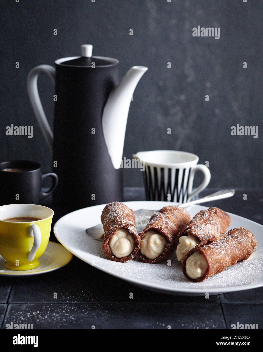 Plate of ricotta cannoli with pot of coffee Stock Photo