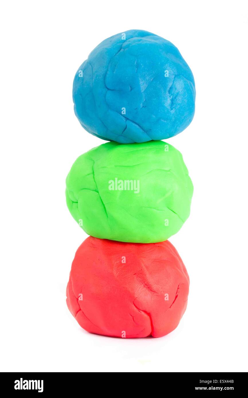 A stack of blue, green and red balls of play doh modeling clay over white Stock Photo