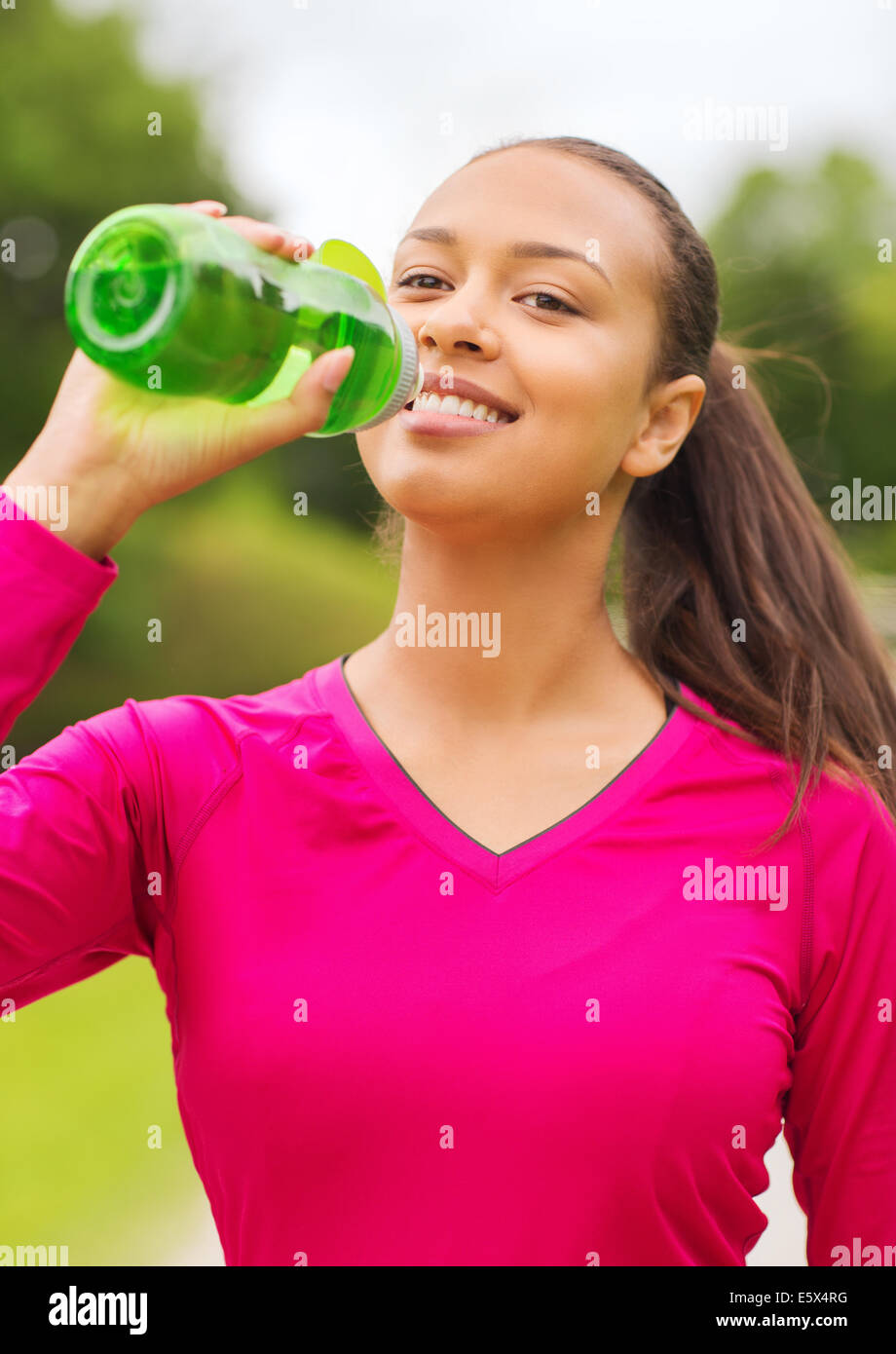 smiling woman drinking from bottle Stock Photo Alamy