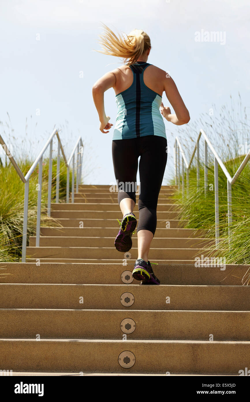 Woman running up stairs Stock Photo Alamy