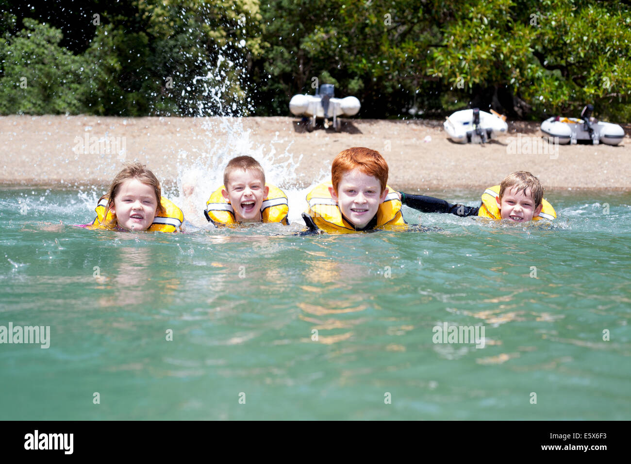 Brothers and sister in a row swimming in sea Stock Photo