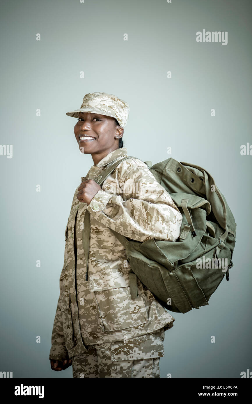 Side view studio portrait of confident female soldier with rucksack Stock Photo