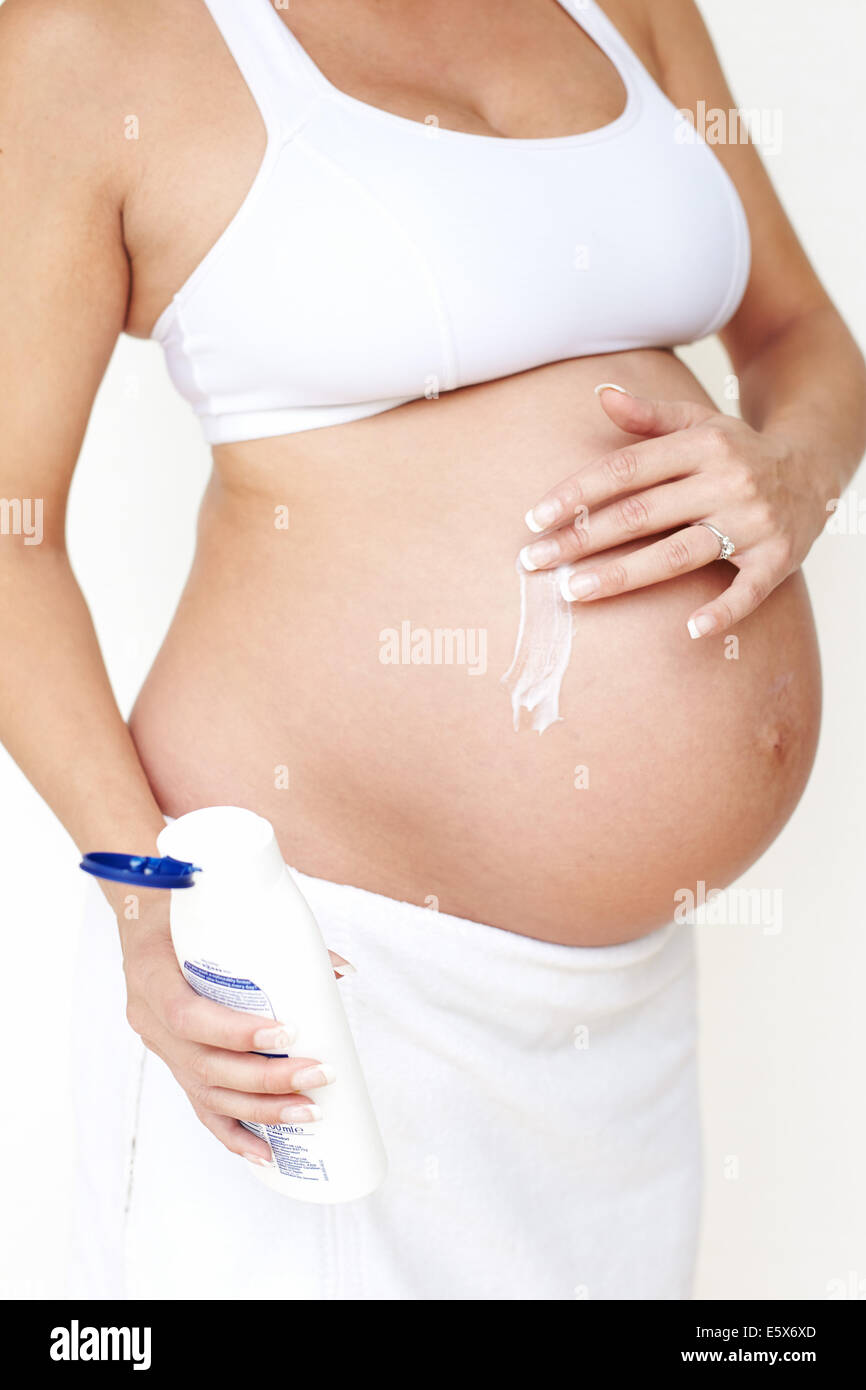 Pregnant woman moisturising Stock Photo