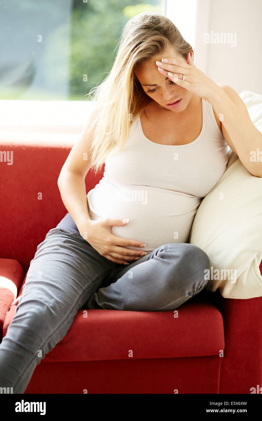 Pregnant woman sat alone Stock Photo