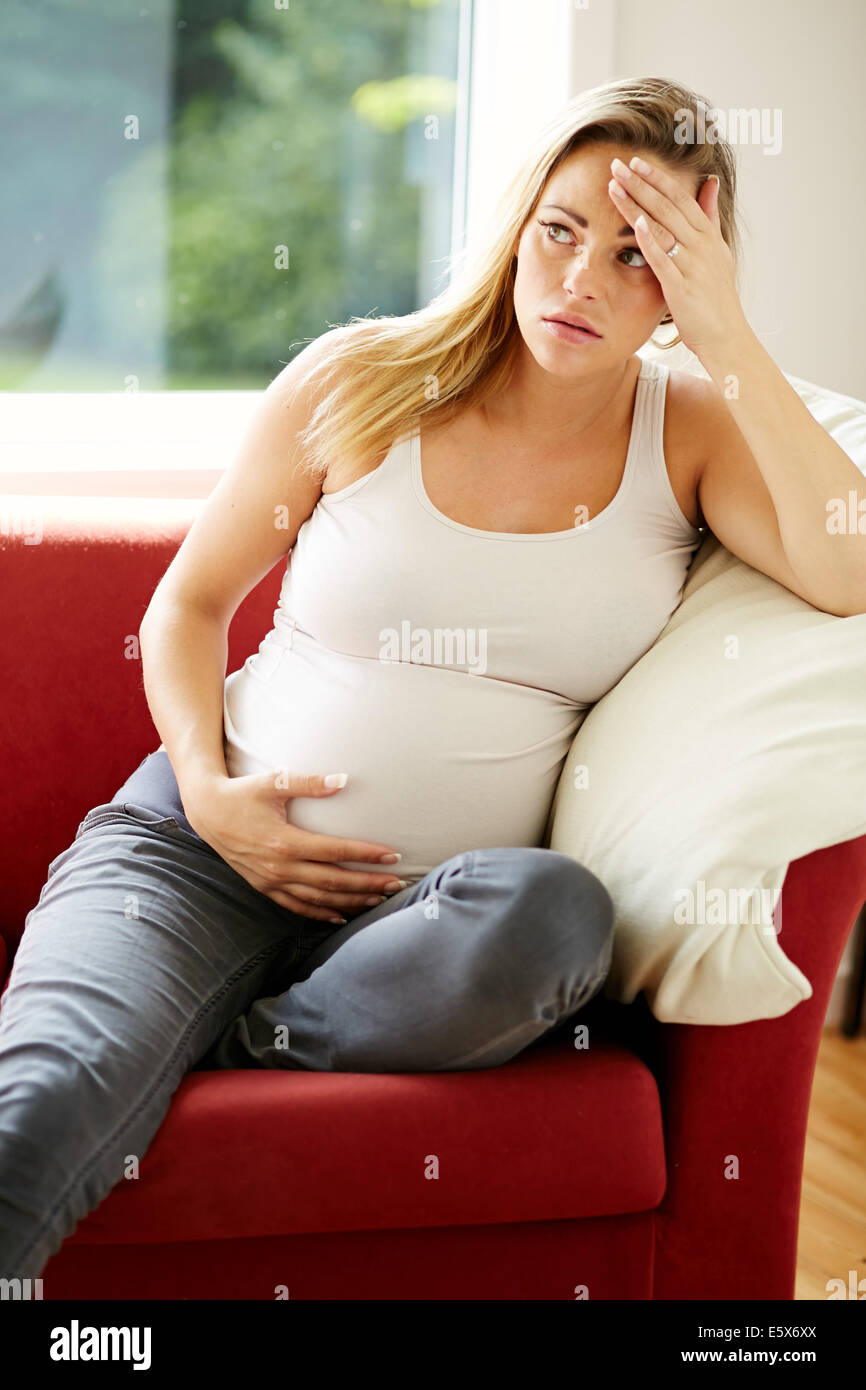 Pregnant woman sat alone Stock Photo