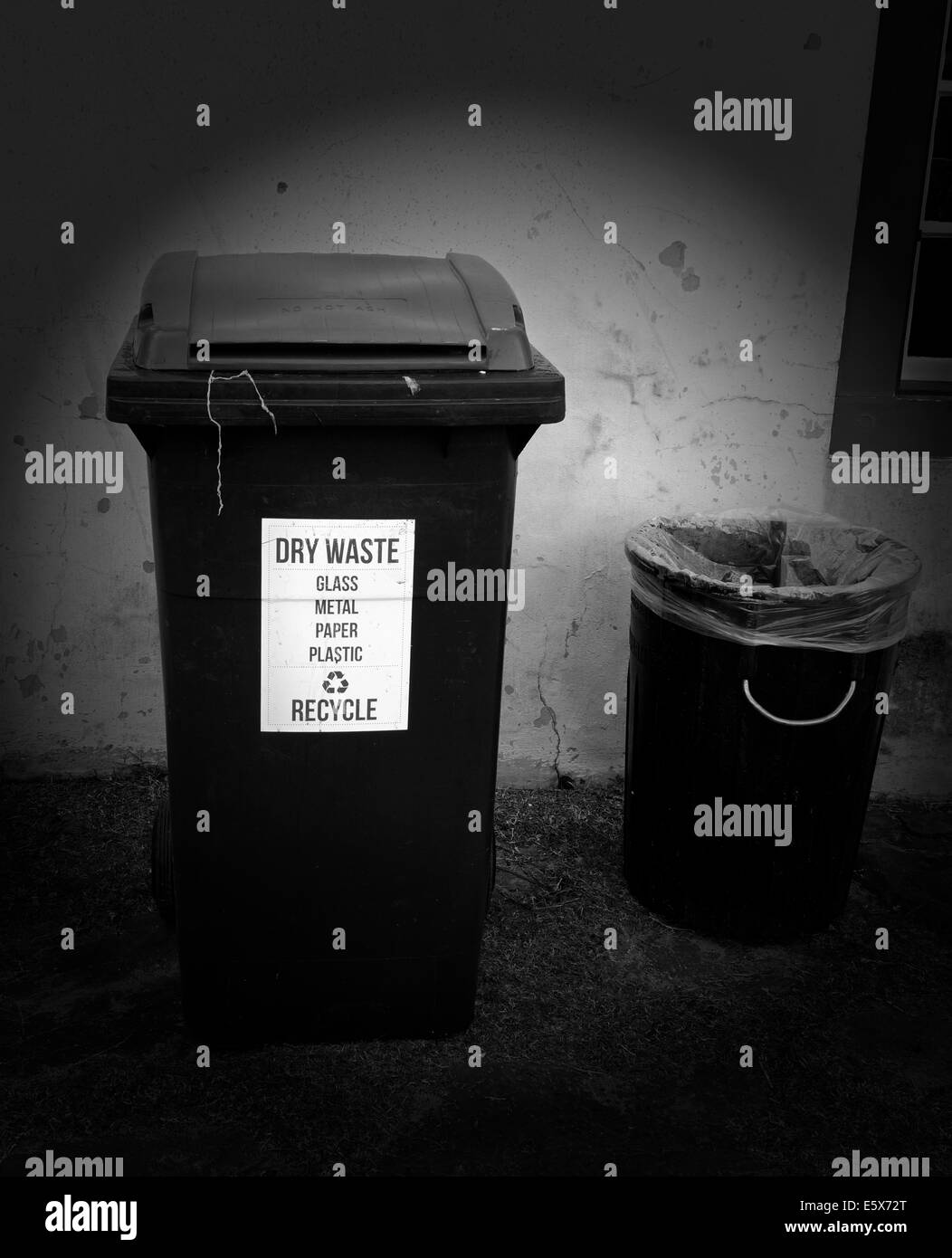 Black and white image of wheelie bin and old bin. Stock Photo