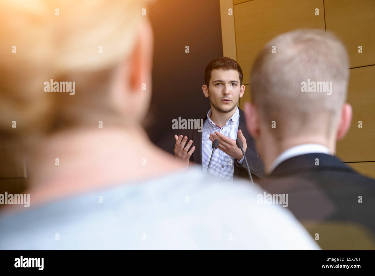Young businessman speaking to audience in conference room Stock Photo