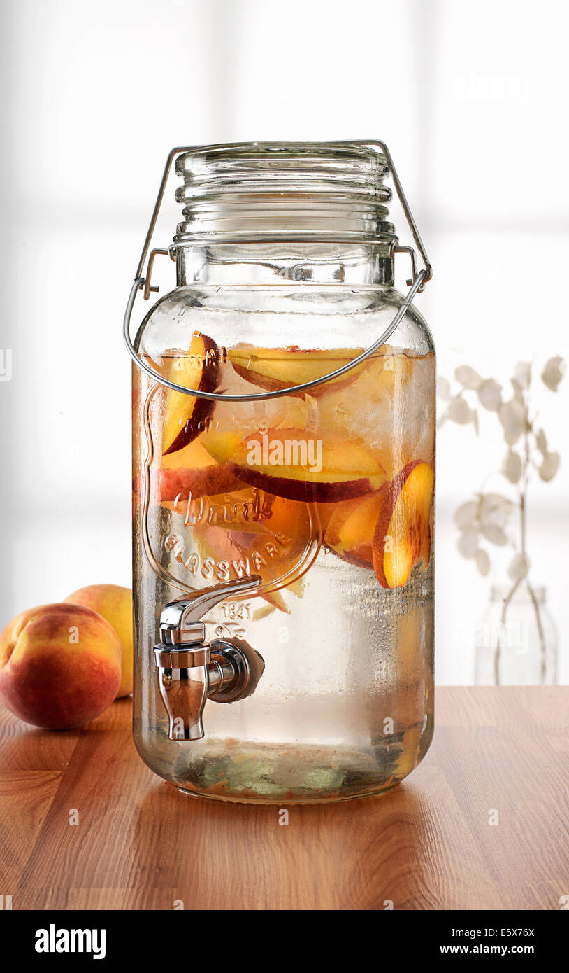 https://c8.alamy.com/comp/E5X76X/glass-jar-with-tap-dispenser-containing-fresh-peach-drink-E5X76X.jpg