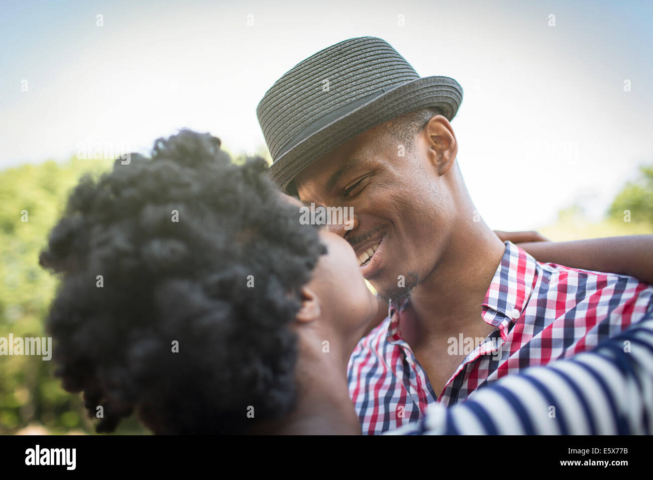 Young couple smiling and hugging in park Stock Photo - Alamy