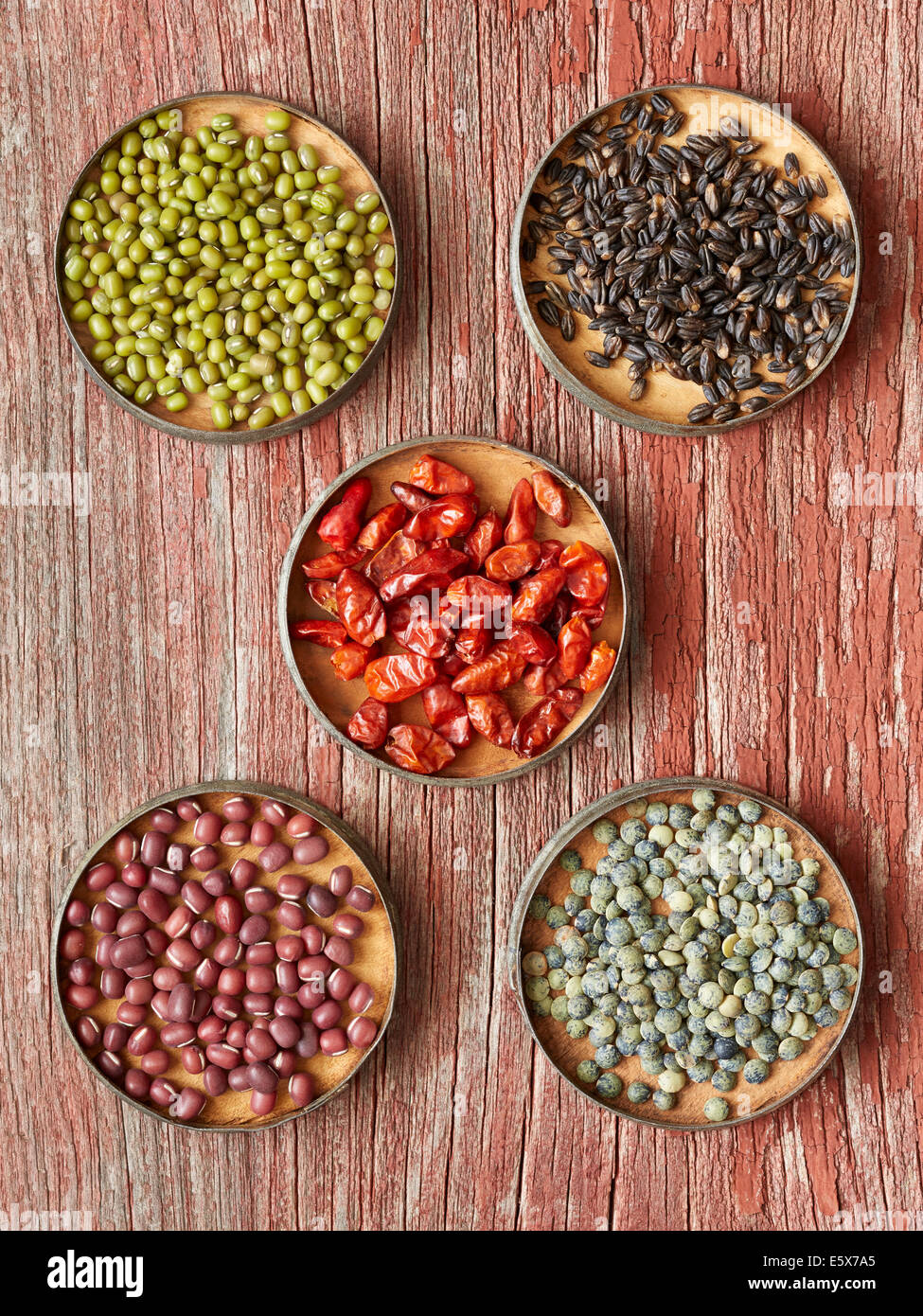 Five dishes containing dried food: Mung Beans, Black Barley, Pequin Chiles, Adzuki Beans, French Green Lentils Stock Photo