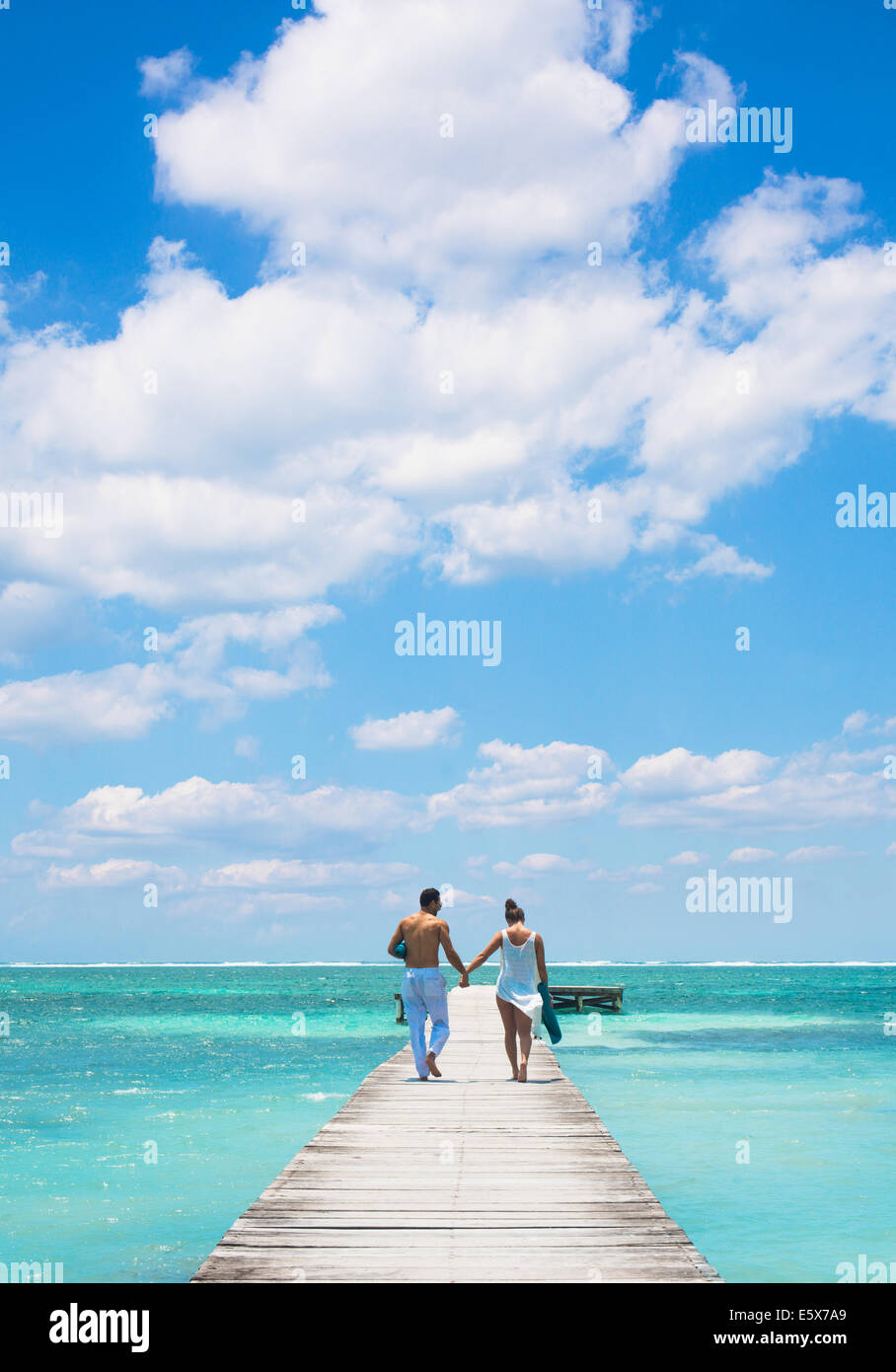 Young couple walking on pier, San Pedro, Belize Stock Photo
