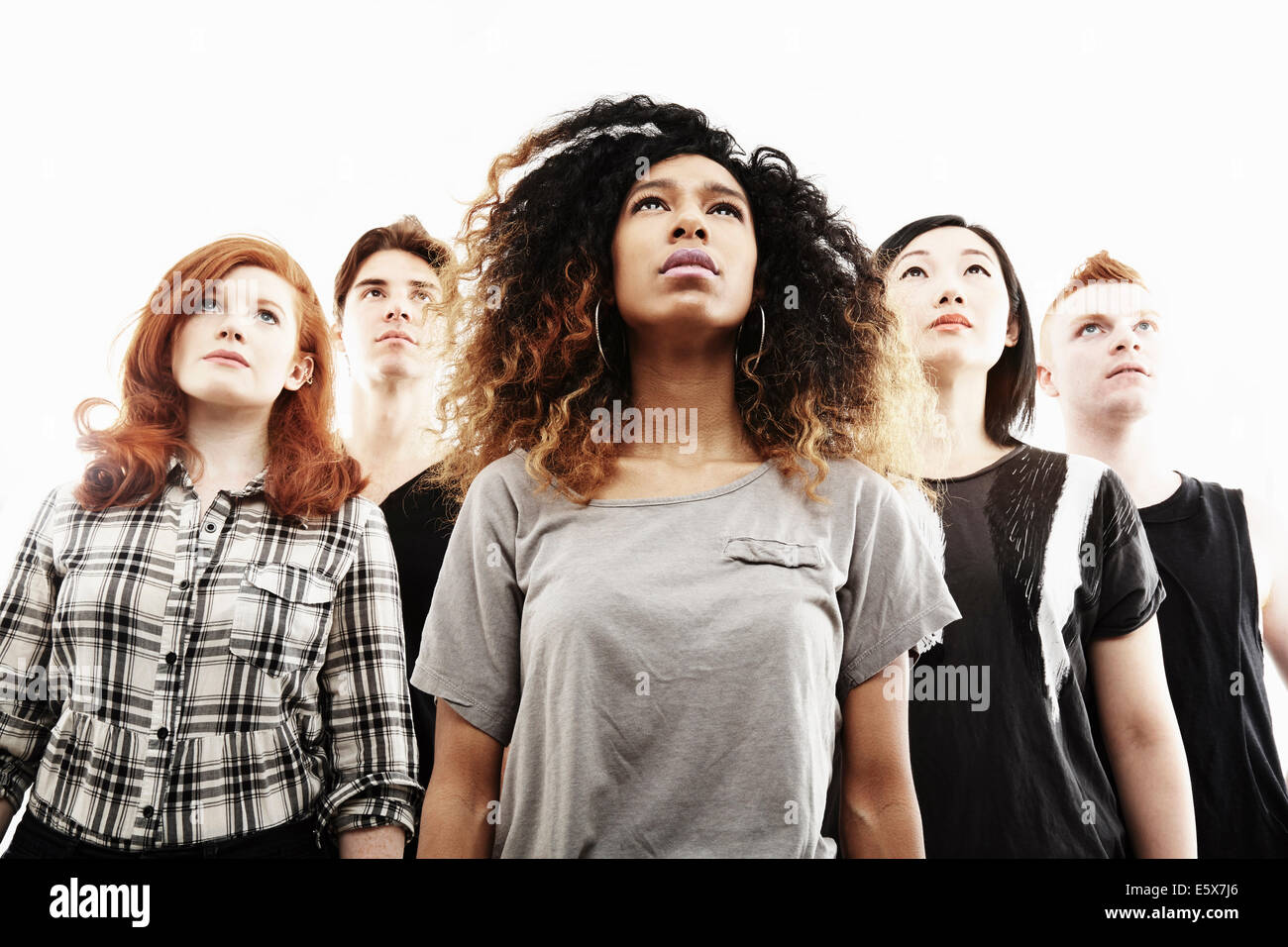 Low angle studio portrait of five young adults looking upward Stock Photo