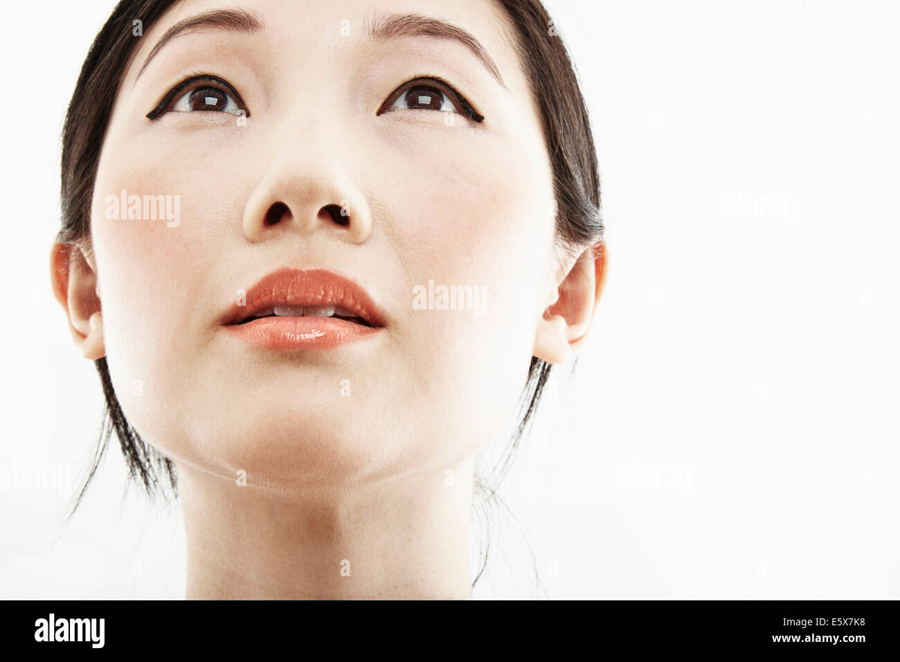 Close up studio portrait of young woman looking up Stock Photo - Alamy