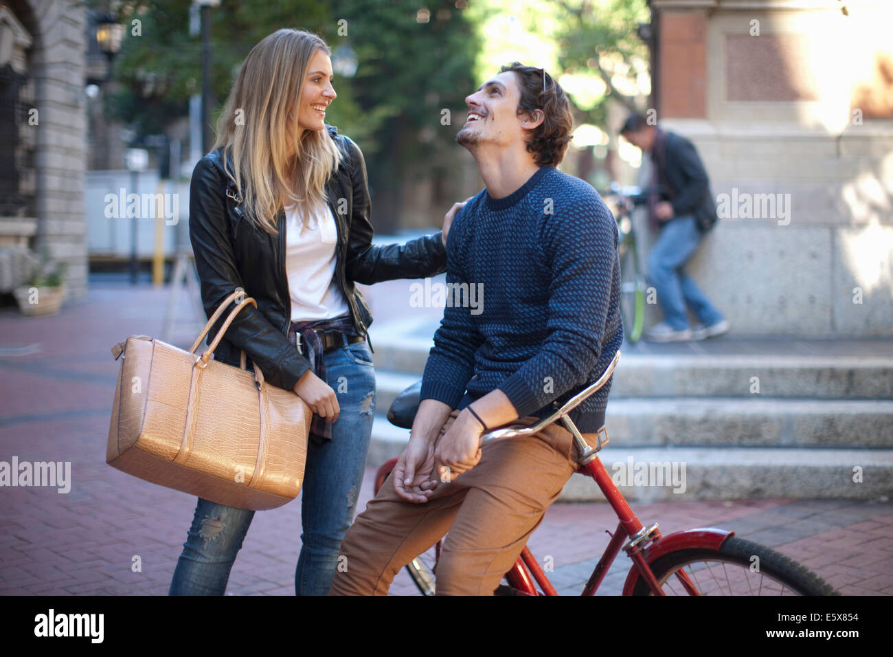 Young woman with boyfriend leaning on bicycle, Cape Town, South Africa Stock Photo