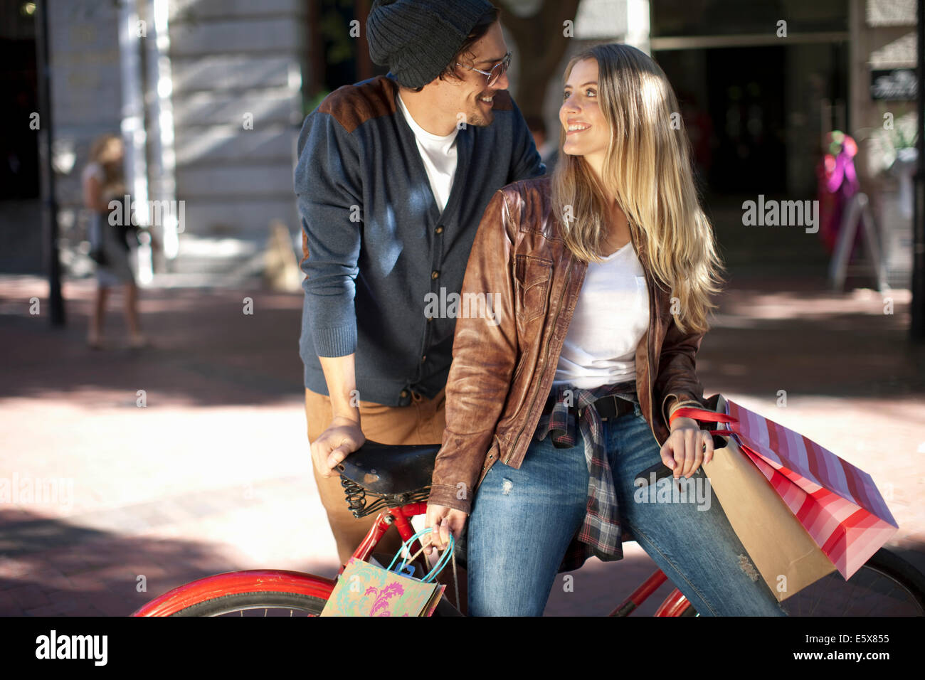 Smiling young woman and boyfriend leaning on bicycle, Cape Town, South  Africa Stock Photo - Alamy