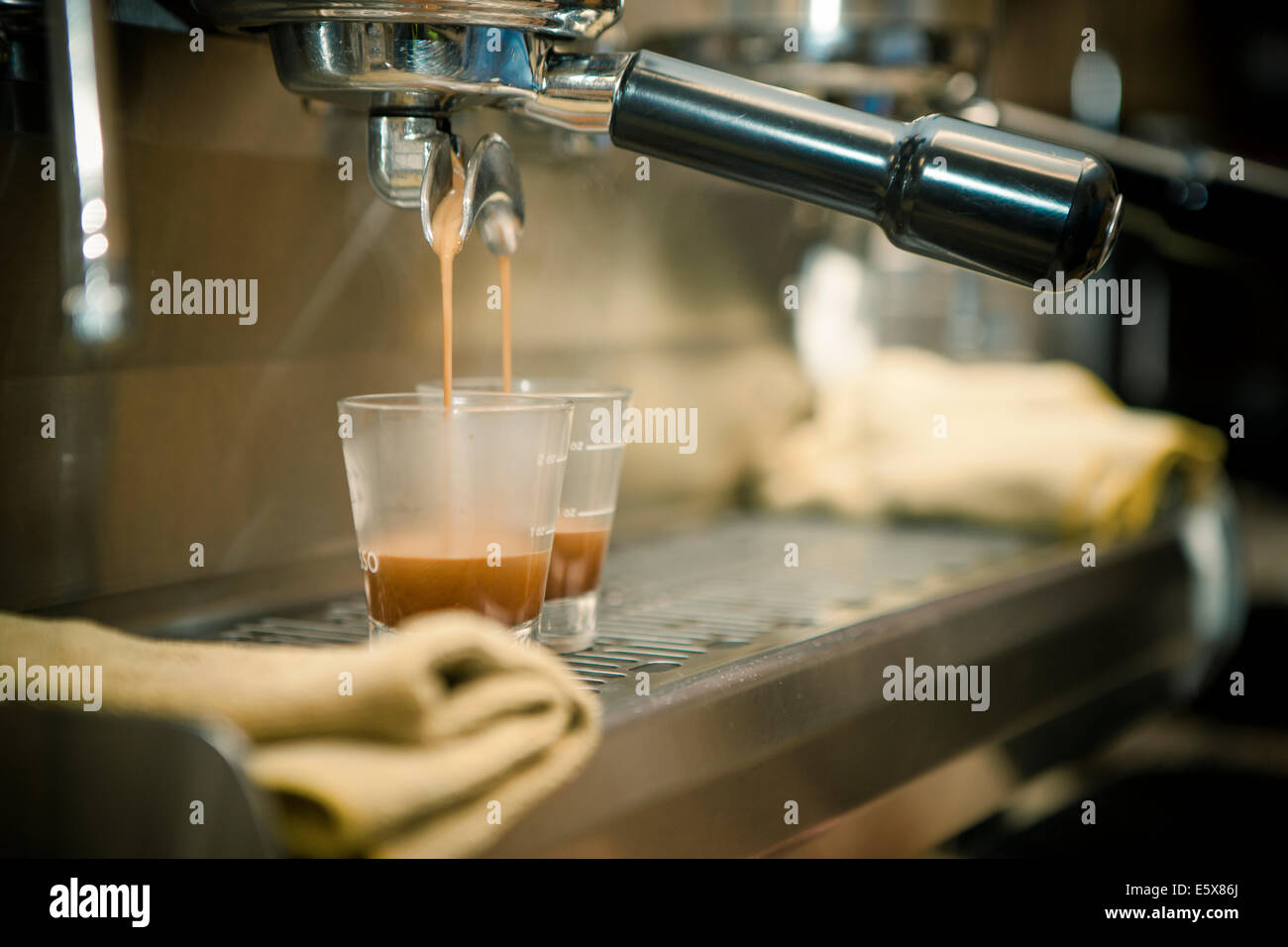 Close-up of espresso machine and shot glasses during a pour Stock