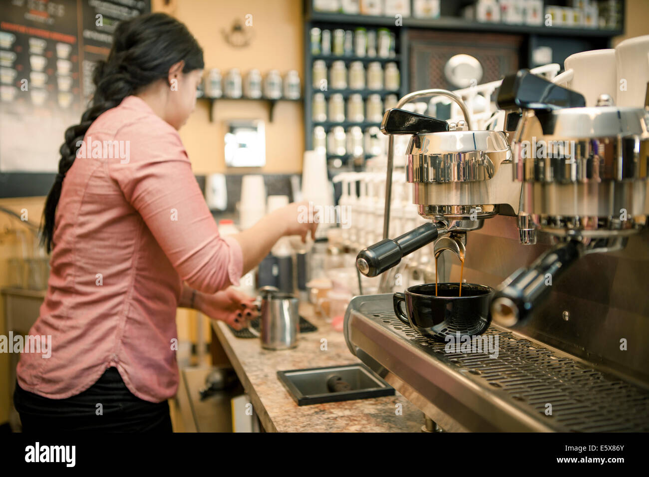 Barista busy with espresso machine in cafe Stock Photo