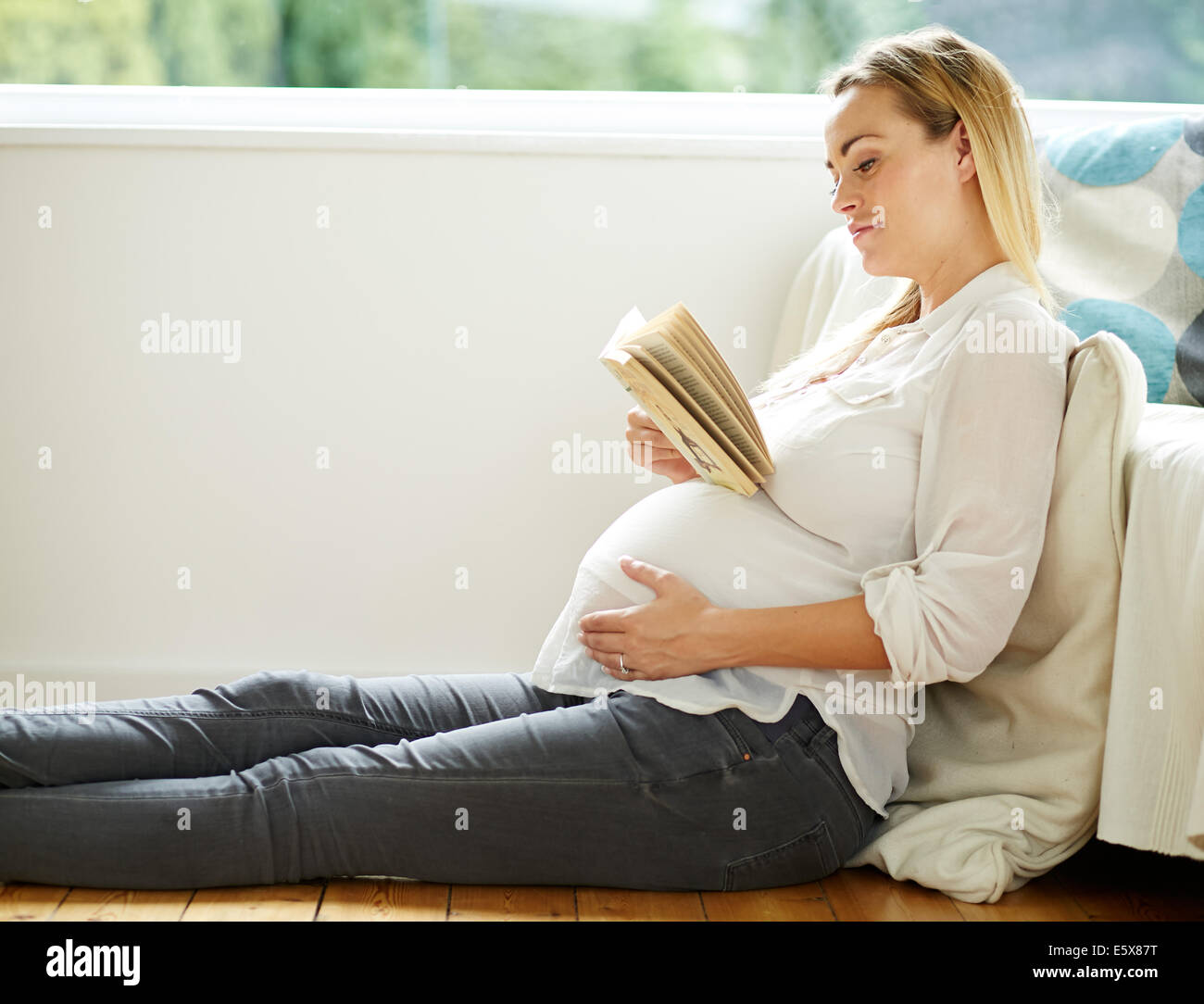 Pregnant woman reading book Stock Photo