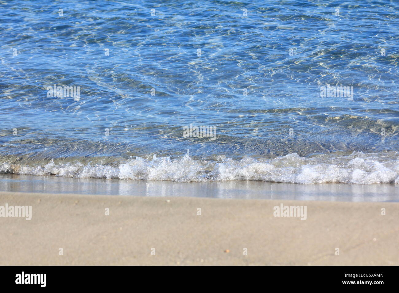 calm sea lapping against white sandy beach Stock Photo