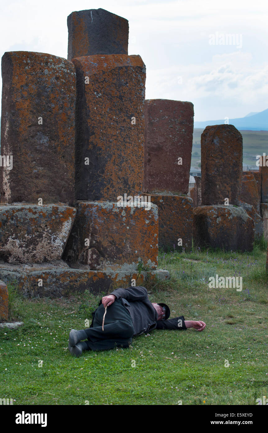 Old sheperd sleeping among tombs, Noratus cemetery, Armenia Stock Photo