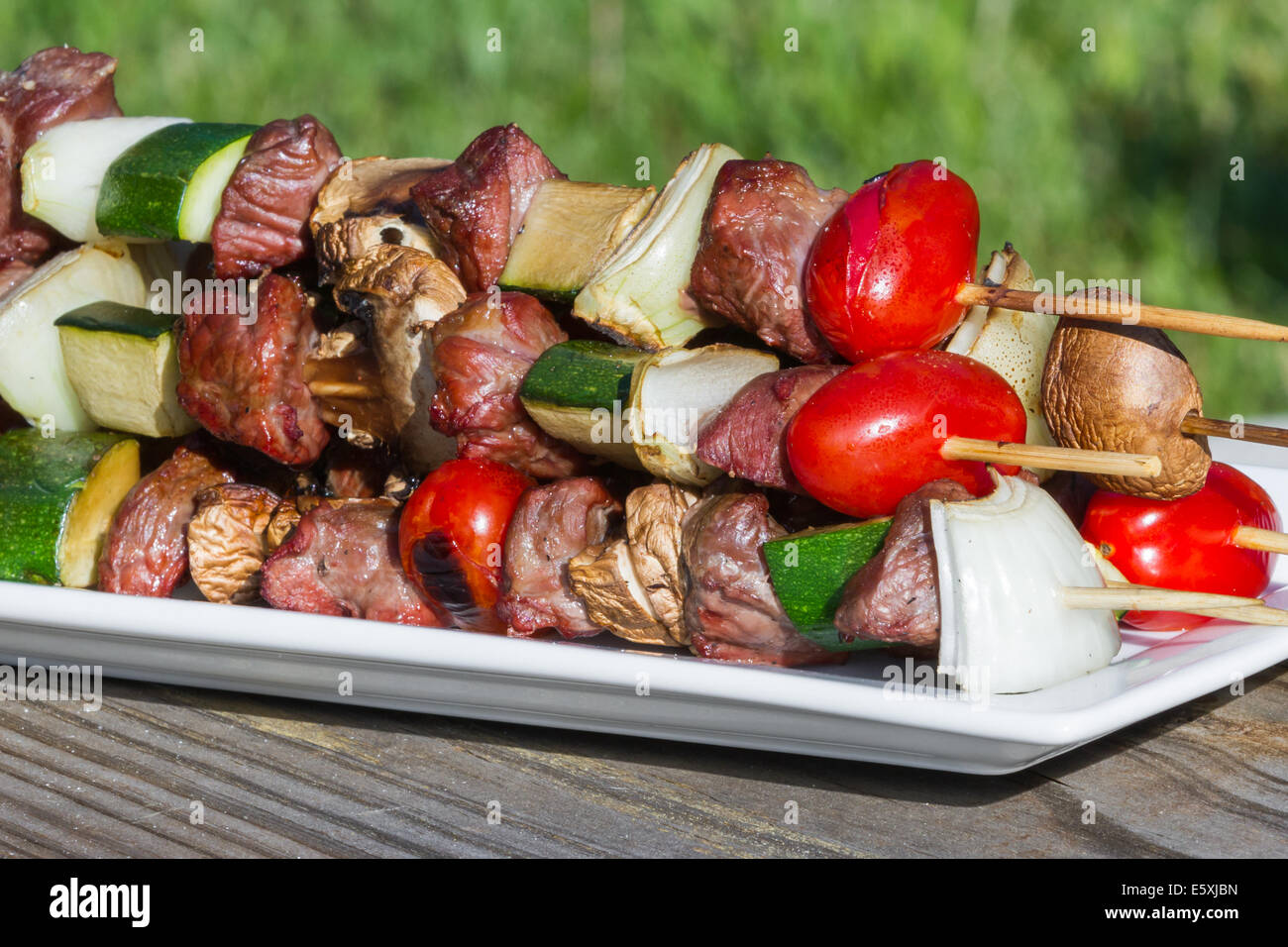 meat and vegetable skewers on a plate with seasonings for an outdoor meal Stock Photo