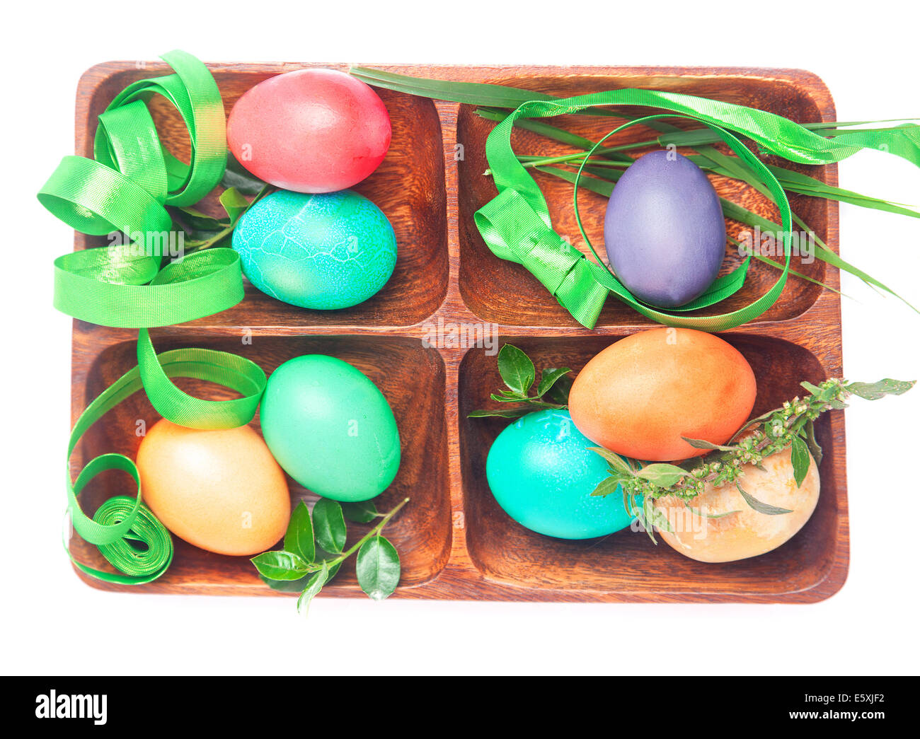 Easter set of hand-dyed vibrant color eggs decorated with bows and green ribbon isolated on white Stock Photo