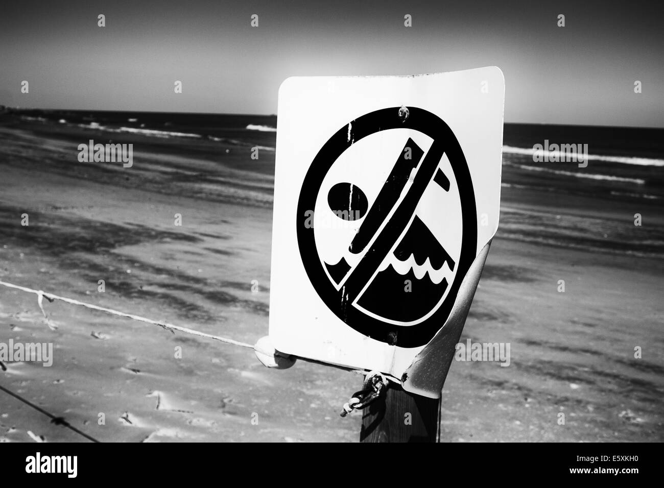 A no swimming sign located near a jetty along the Galveston Seawall. Stock Photo
