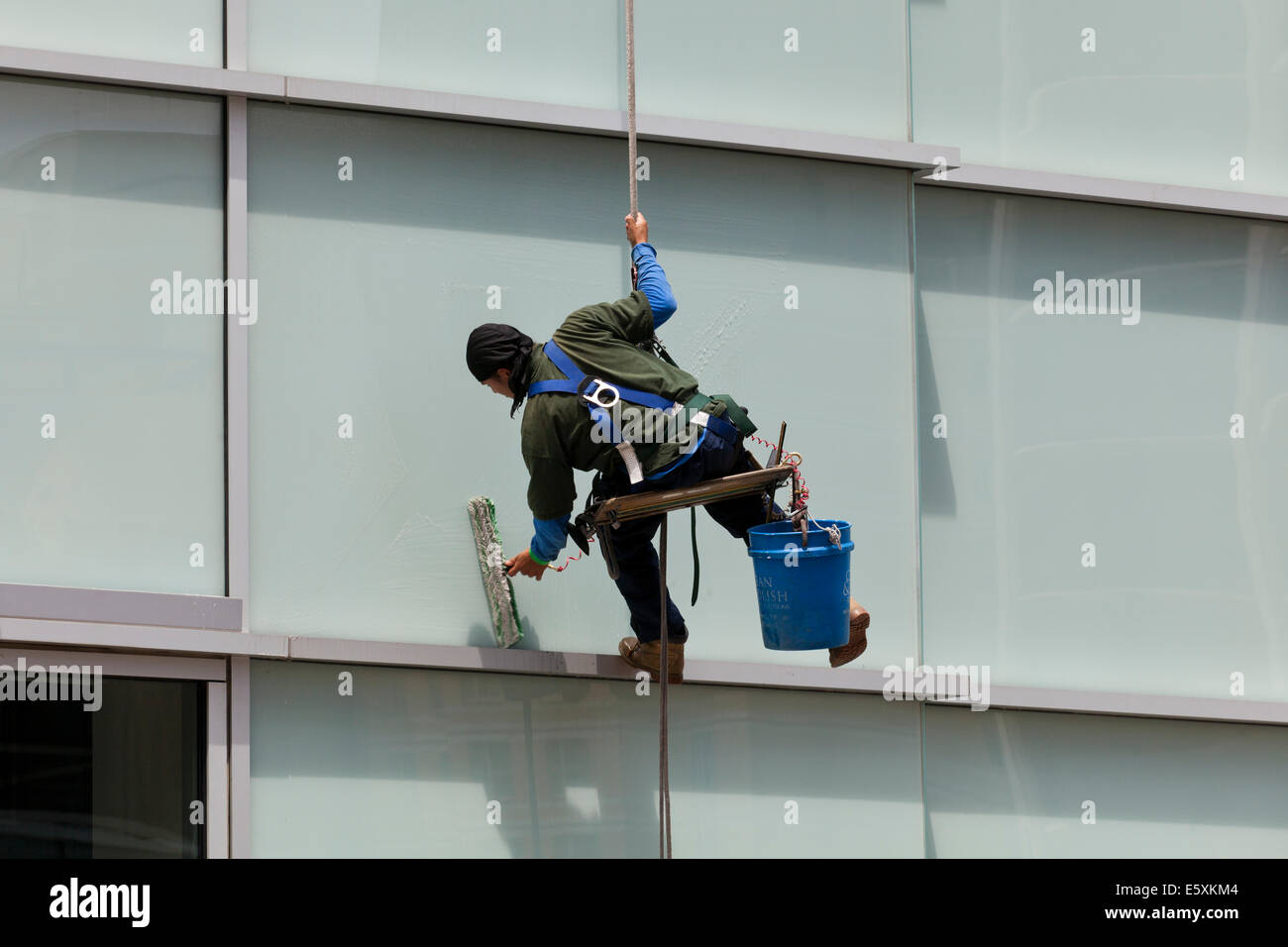 High rise window cleaner  sitting in a bosun's chair - USA Stock Photo
