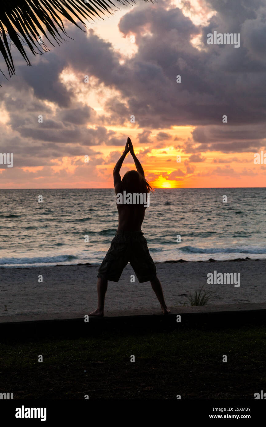 Silhouette of guy on beach at sunset Stock Photo