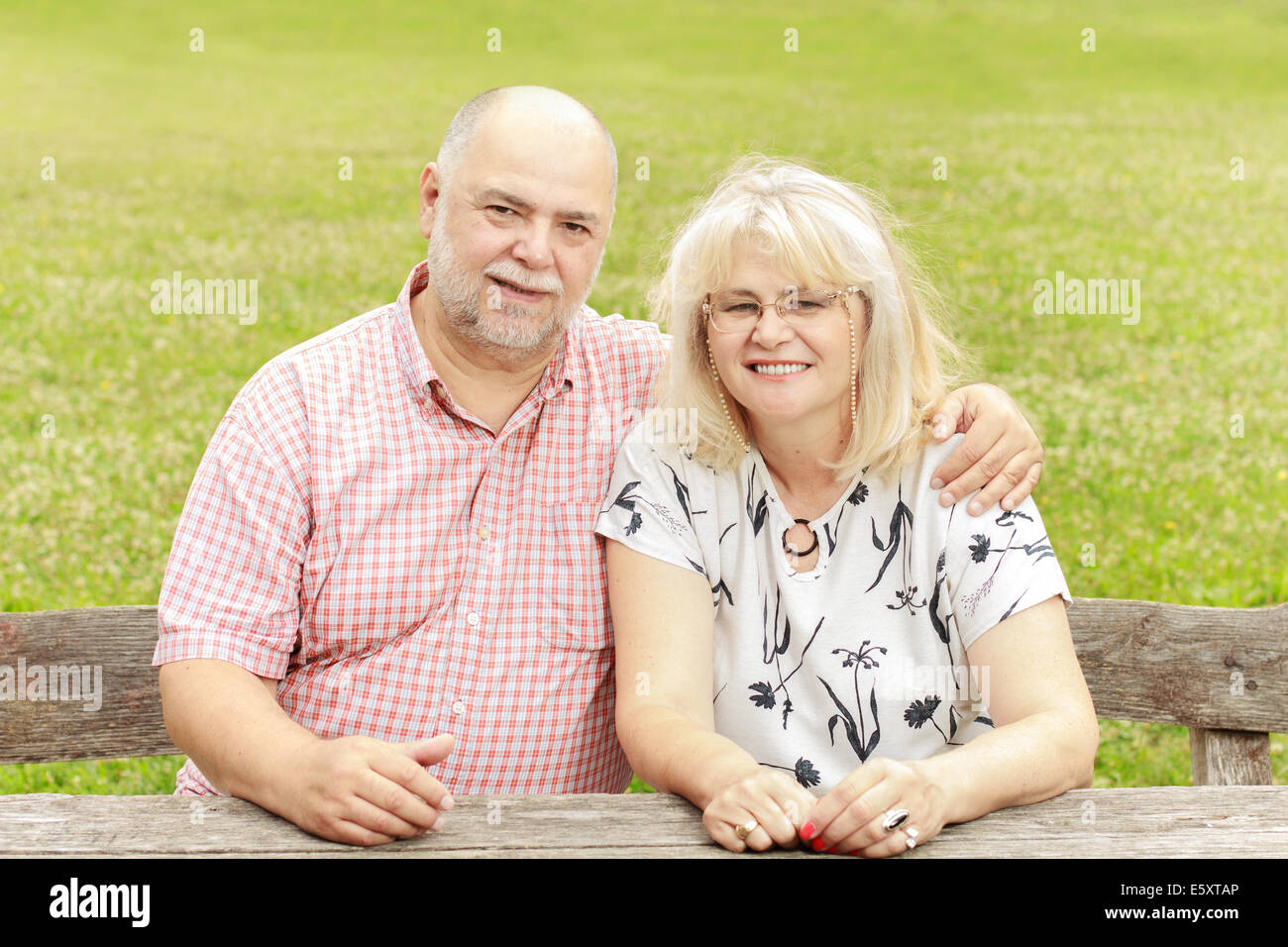 Elderly couple relaxing on the bench in park Stock Photo - Alamy