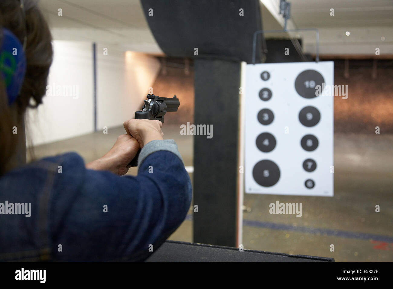 Young woman shooting a handgun at a shooting range in Minneapolis USA
