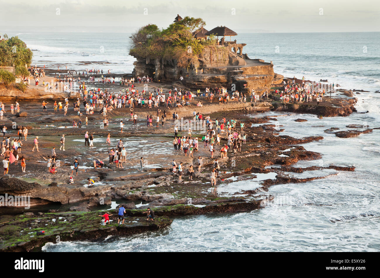 Tanah Lot temple in Bali with mass of tourists gathered to view the sunset  at the famous rock temple on the Bali coastline. A natural coastal feature  Stock Photo - Alamy