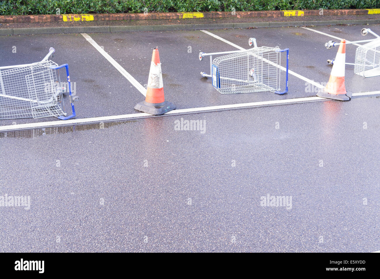 Out of use car parking spaces blocked with overturned shopping trolleys. Stock Photo