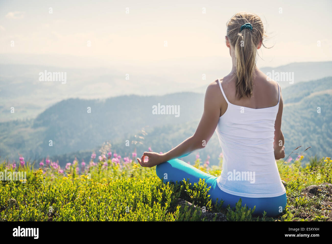 Young woman meditate on the top of mountain Stock Photo
