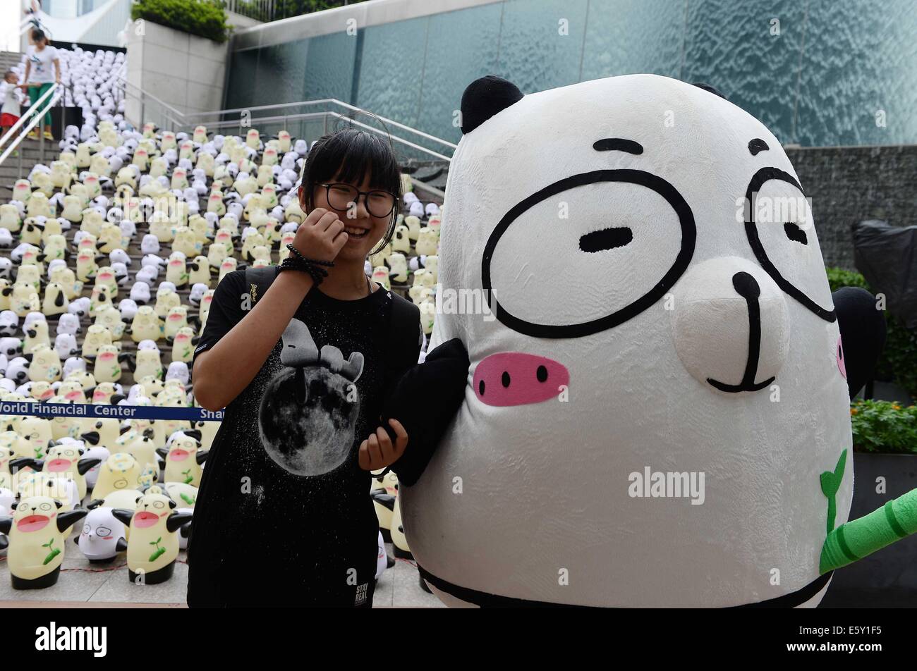 Shanghai, China. 8th Aug, 2014. A tourist poses for photo with
