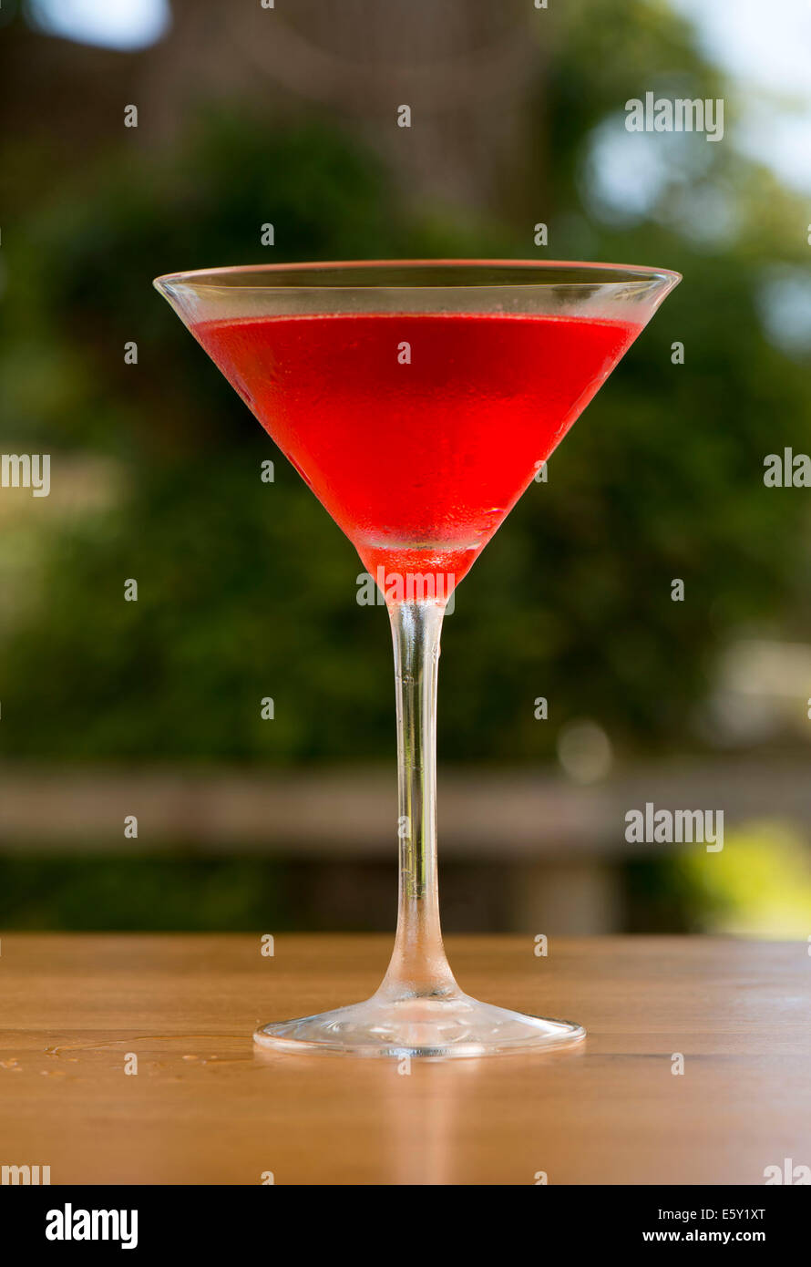 A strawberry red alcoholic drink in a cocktail glass. Stock Photo