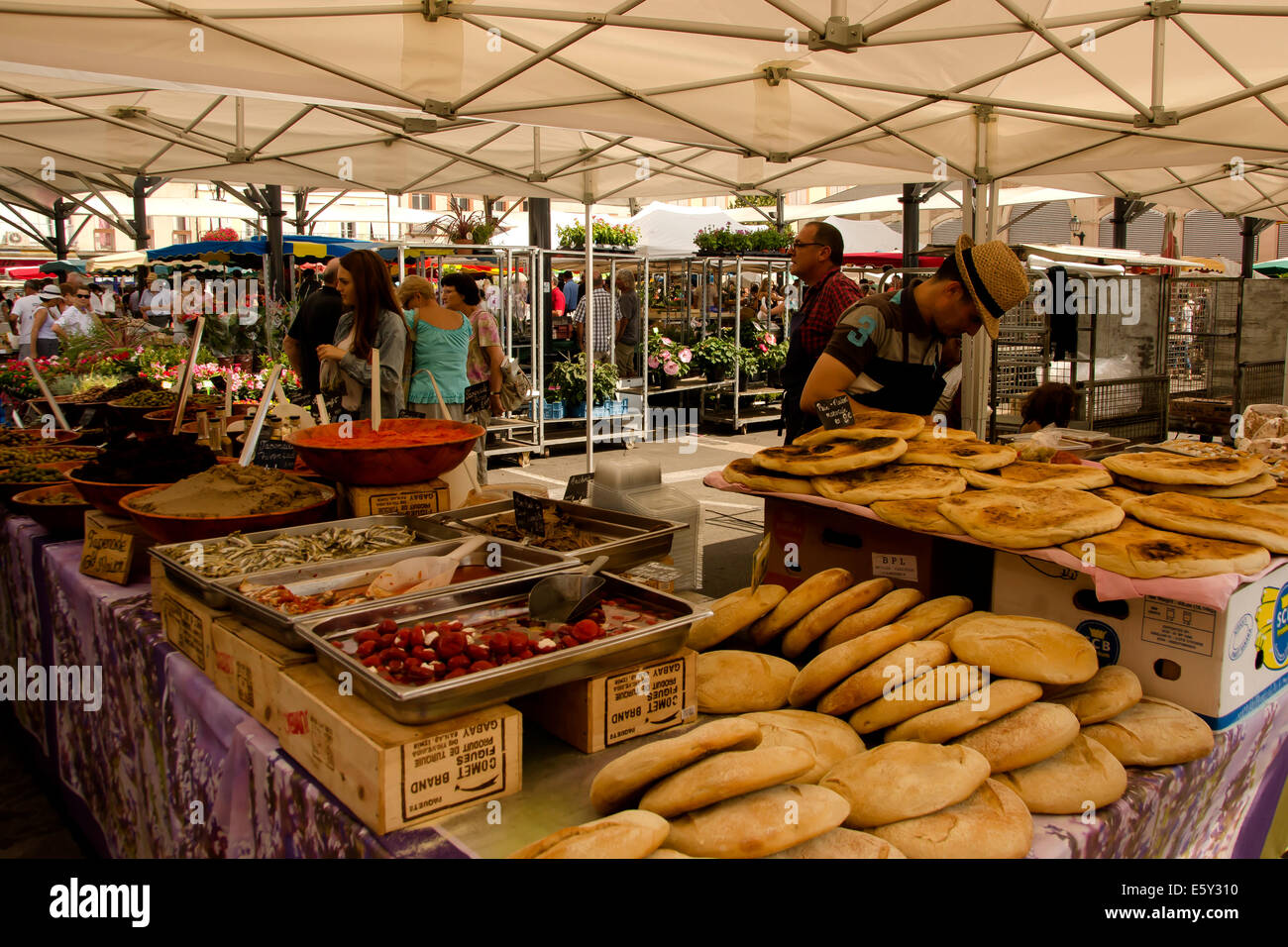 Arab bread and multiple delicacies in stall in Moissac Sunday market, south west France, illustrating North African influence. Stock Photo