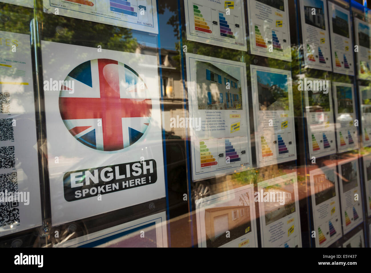 Estate agent window with 'english spoken here' sign selling housed to the expat market. Stock Photo