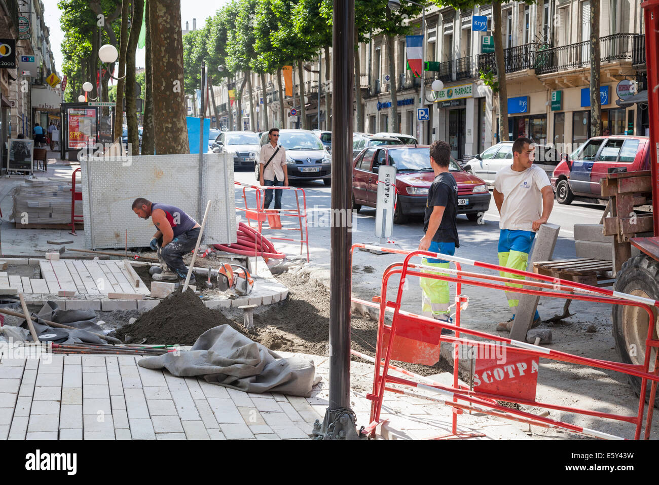 French workmen replacing a section of city pavement . Stock Photo