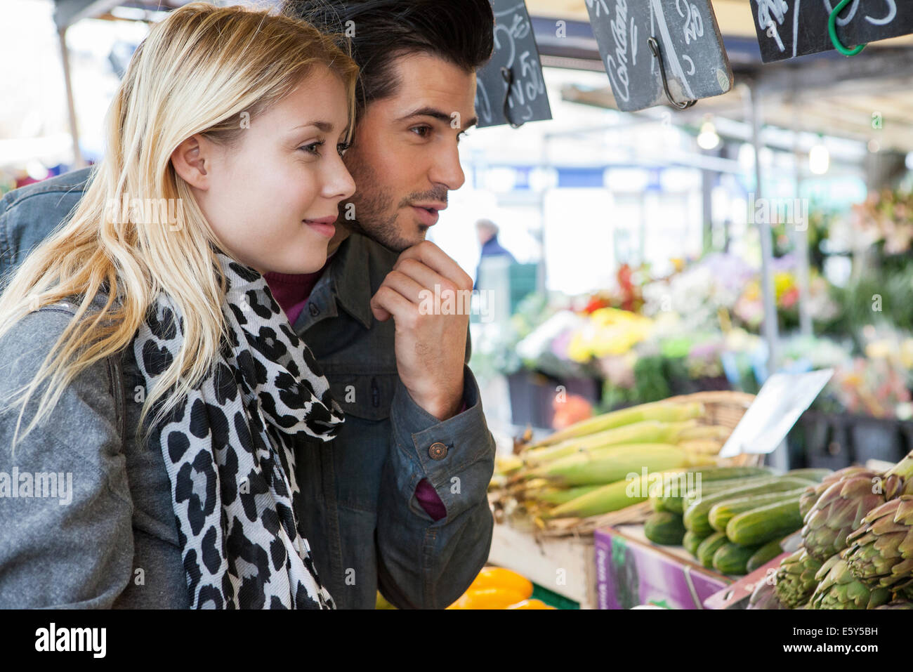Young couple at greengrocer's shopping for fresh fruits and vegetables Stock Photo