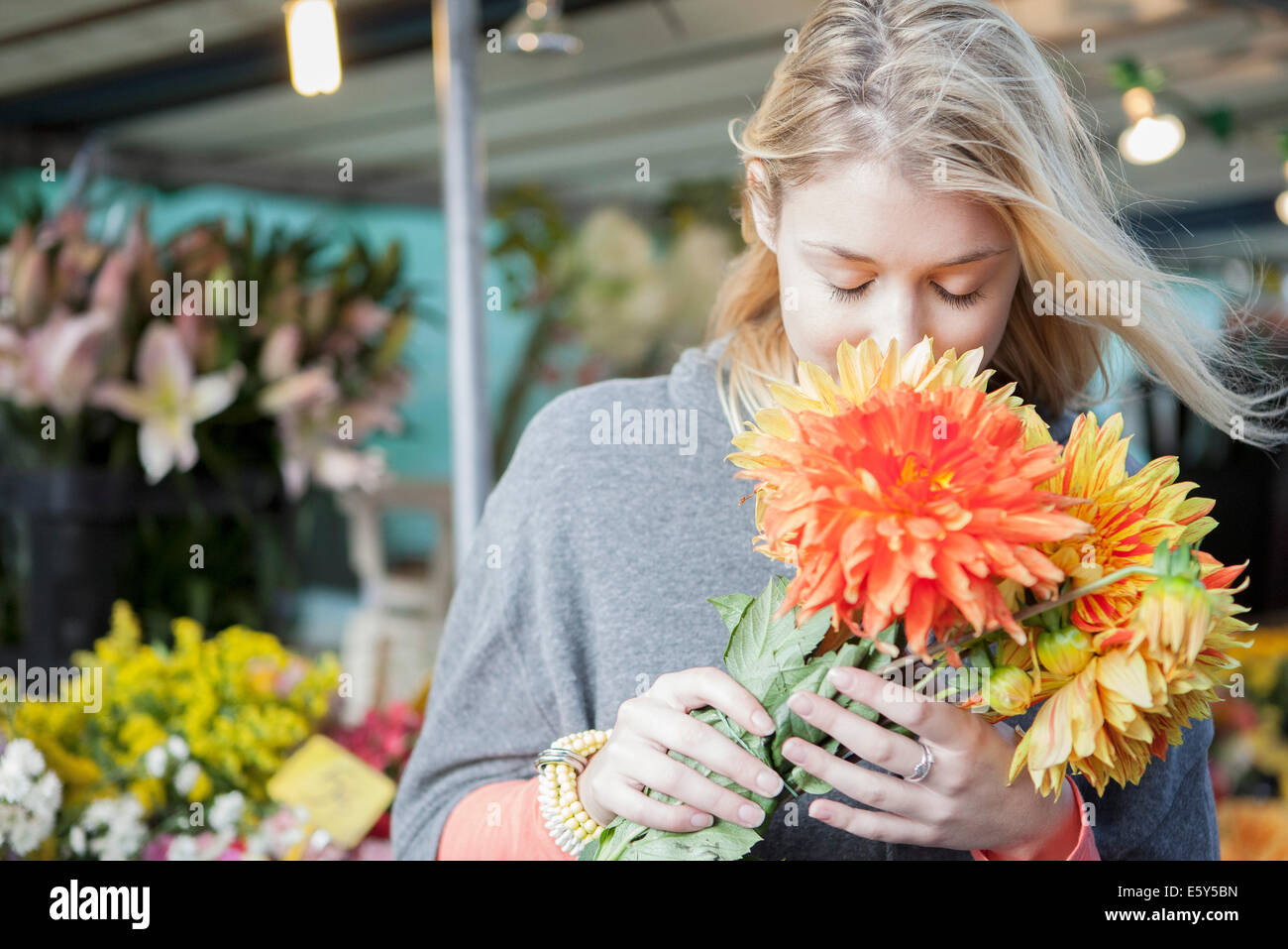 Young woman appreciating flower bouquet fragrance Stock Photo