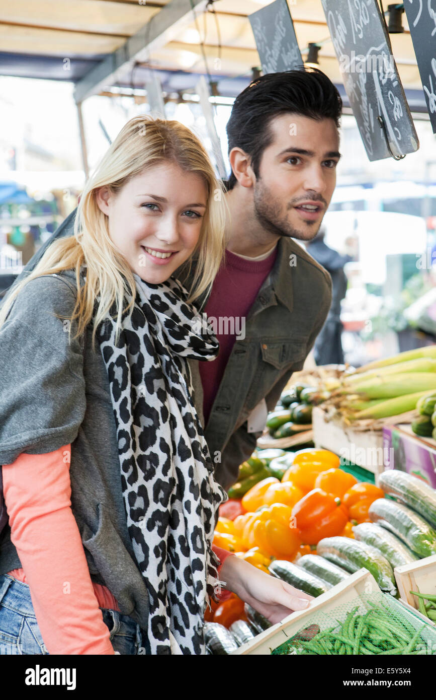 Young couple at greengrocer's shopping for fresh fruits and vegetables Stock Photo